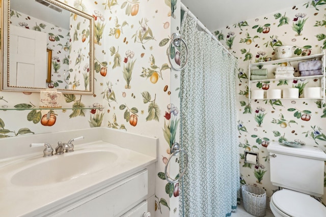 bathroom featuring visible vents, vanity, toilet, and wallpapered walls