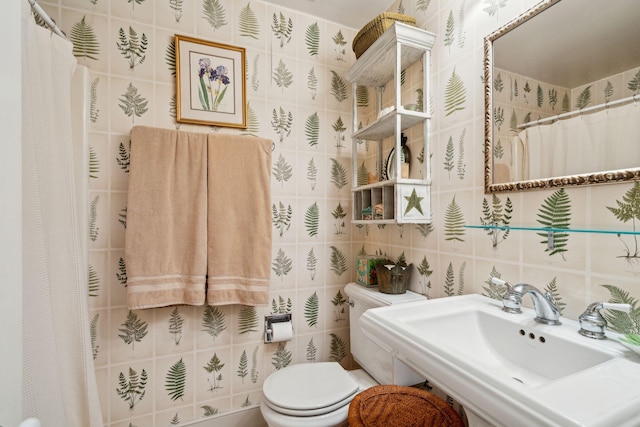 full bathroom featuring toilet, tile walls, and a sink