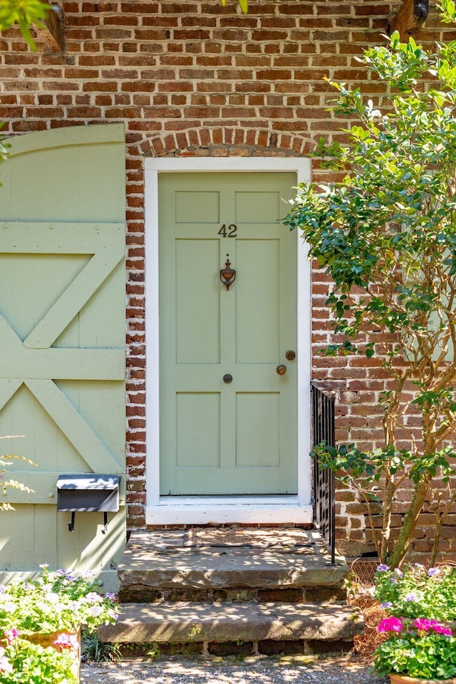 doorway to property with brick siding