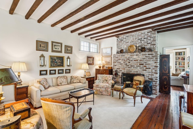 living room featuring hardwood / wood-style flooring, a brick fireplace, and beamed ceiling