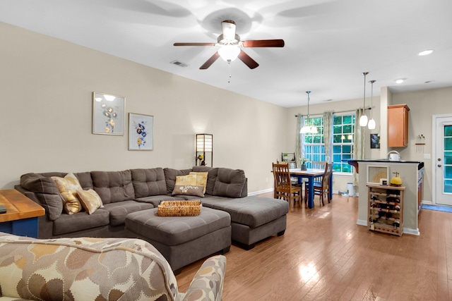 living room featuring ceiling fan and light hardwood / wood-style flooring