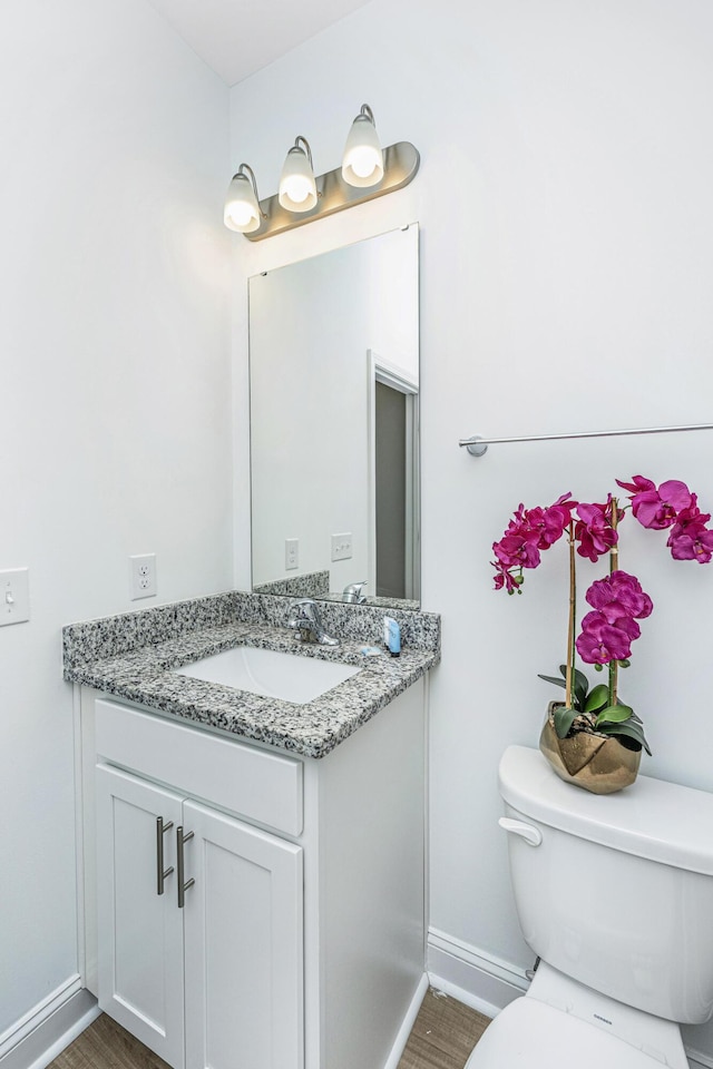 bathroom featuring hardwood / wood-style flooring, vanity, and toilet