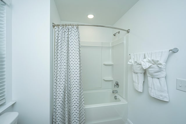 bathroom featuring shower / tub combo with curtain and toilet