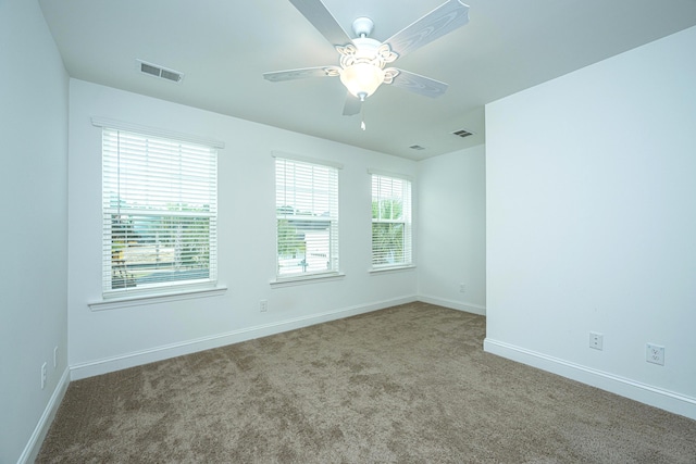 carpeted spare room featuring ceiling fan