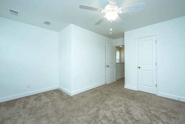 carpeted spare room featuring ceiling fan