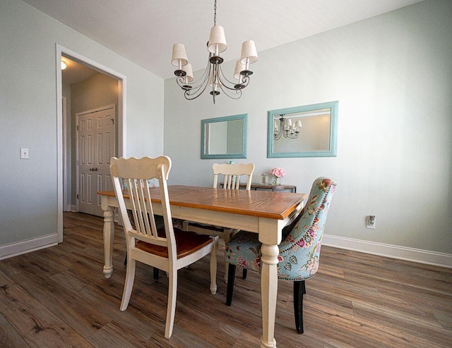 dining area featuring dark hardwood / wood-style floors and a chandelier