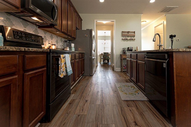 kitchen featuring dark wood-type flooring, sink, ornamental molding, decorative backsplash, and black appliances