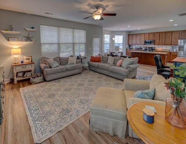 living room featuring ceiling fan and light hardwood / wood-style floors