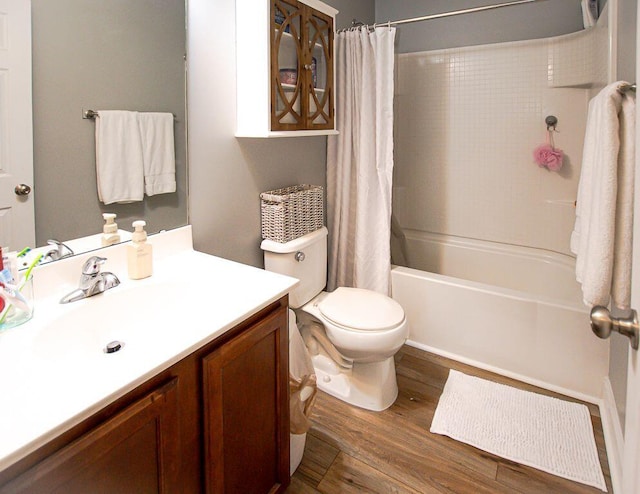 full bathroom with hardwood / wood-style flooring, shower / tub combo with curtain, vanity, and toilet