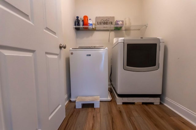 washroom featuring hardwood / wood-style flooring and washing machine and clothes dryer