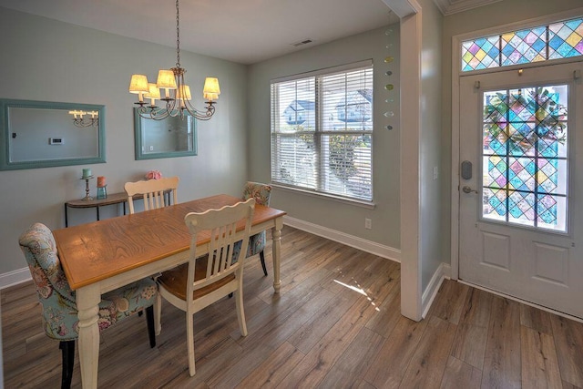 dining space with hardwood / wood-style flooring and a chandelier