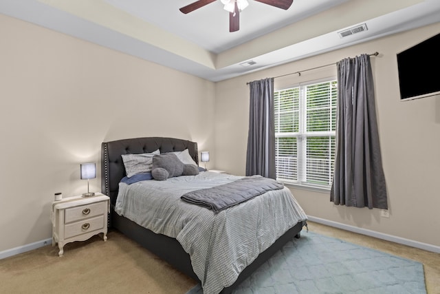 bedroom featuring visible vents, baseboards, a ceiling fan, and light carpet