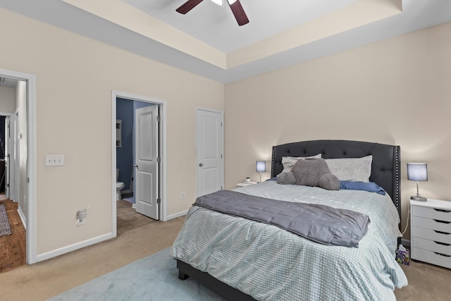 bedroom with a raised ceiling, baseboards, a ceiling fan, and carpet floors