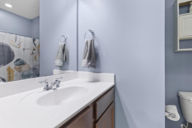 bathroom featuring a shower with shower curtain, vanity, and toilet