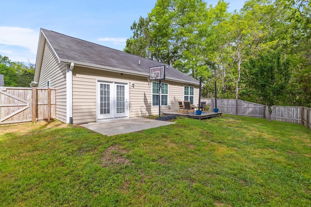 rear view of property featuring a patio area, a fenced backyard, a gate, and a lawn