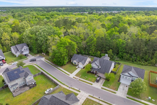 drone / aerial view featuring a wooded view and a residential view