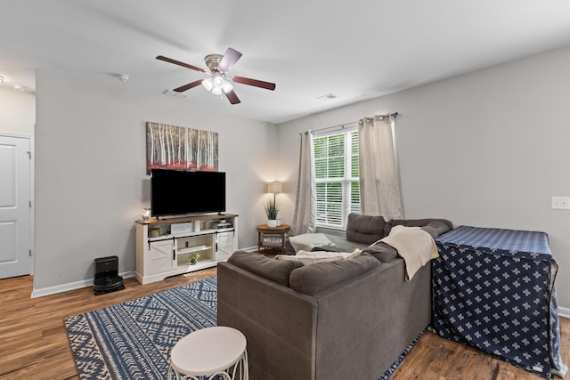 living area with wood finished floors, baseboards, a ceiling fan, and visible vents