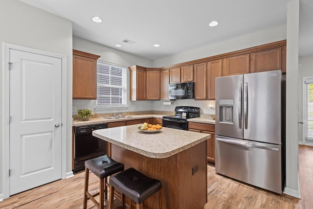 kitchen with visible vents, plenty of natural light, a sink, light countertops, and black appliances