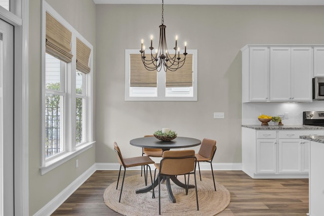 dining room with dark wood-type flooring and an inviting chandelier