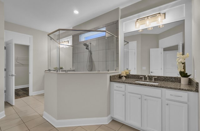 bathroom with a tile shower, tile patterned floors, and vanity