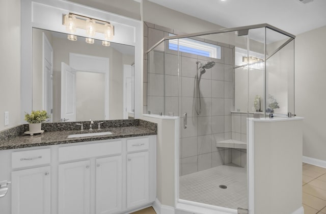 bathroom featuring tile patterned floors, a shower with door, and vanity