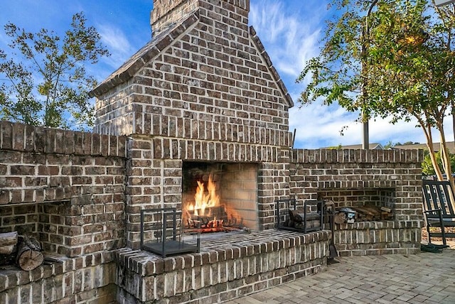 view of patio featuring an outdoor brick fireplace