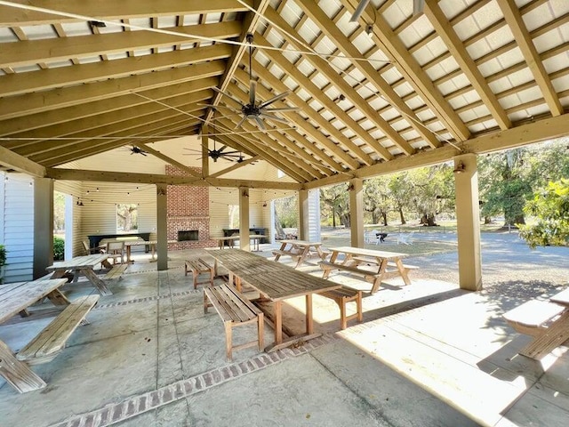 view of patio featuring a gazebo, ceiling fan, and an outdoor brick fireplace