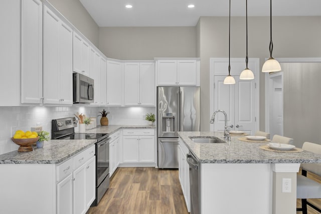 kitchen featuring pendant lighting, white cabinetry, sink, and appliances with stainless steel finishes