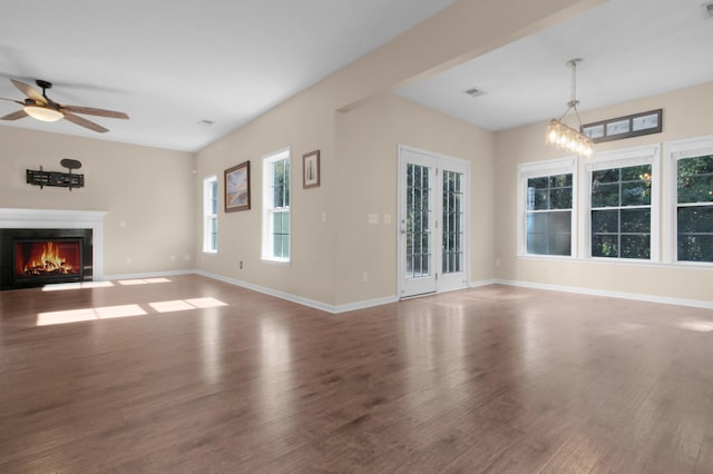 unfurnished living room with hardwood / wood-style floors and ceiling fan with notable chandelier