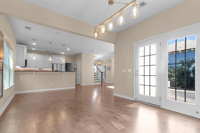 unfurnished living room with hardwood / wood-style flooring and plenty of natural light