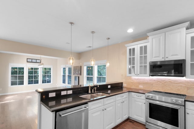 kitchen featuring white cabinets, stainless steel appliances, kitchen peninsula, and sink