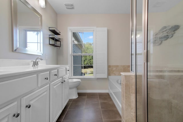 bathroom featuring tile patterned flooring, plenty of natural light, a tub, and vanity