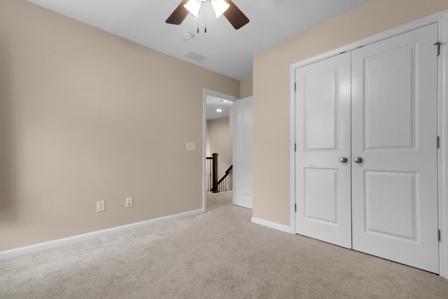 unfurnished bedroom featuring ceiling fan, light carpet, and a closet