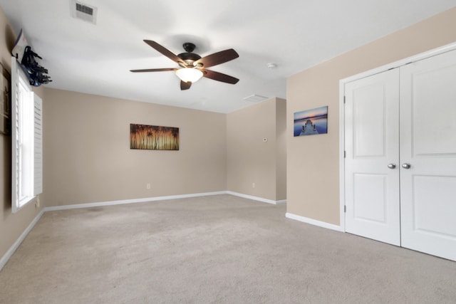 spare room with ceiling fan and light colored carpet