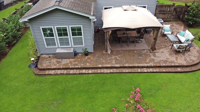 back of property with a gazebo, a patio area, and a lawn