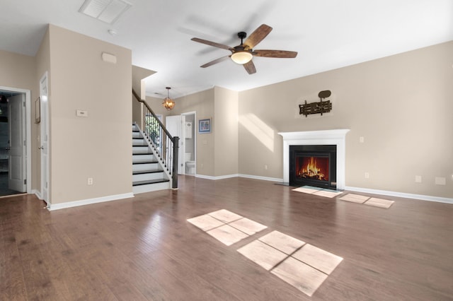 unfurnished living room with dark hardwood / wood-style flooring and ceiling fan with notable chandelier