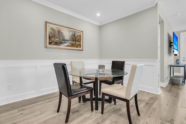 dining room featuring light hardwood / wood-style flooring and ornamental molding