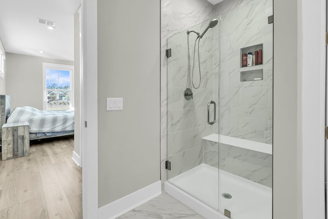 bathroom featuring hardwood / wood-style flooring and walk in shower