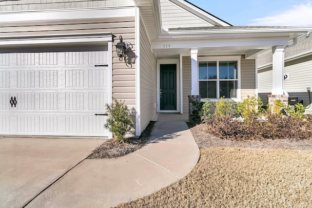 doorway to property featuring a porch and a garage