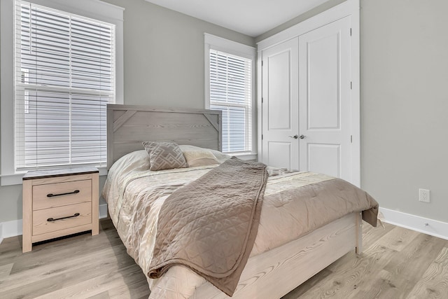 bedroom with light hardwood / wood-style flooring and a closet