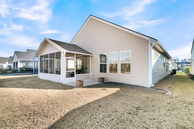 back of house with a lawn and a sunroom