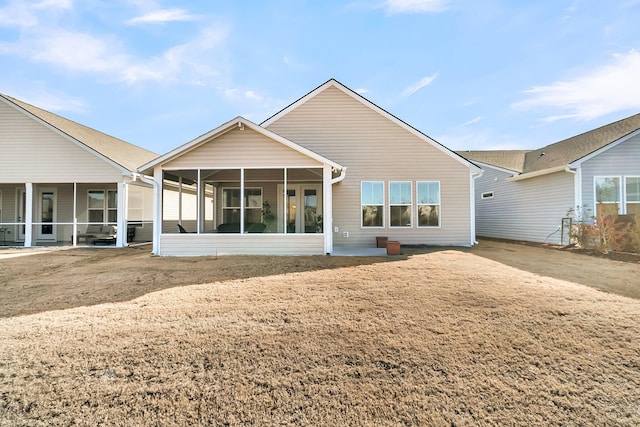 back of house with a lawn and a sunroom