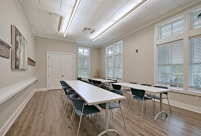 dining area featuring hardwood / wood-style flooring, a wealth of natural light, and ornamental molding