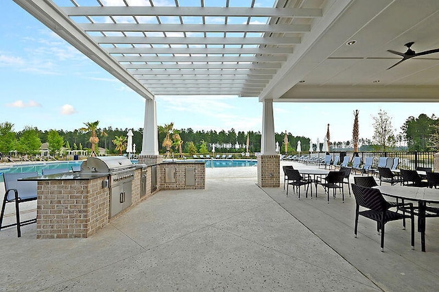 view of patio / terrace featuring a community pool, exterior kitchen, and a grill