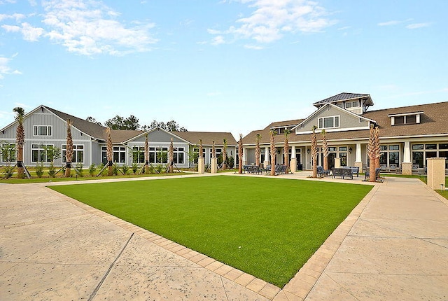 rear view of property with a yard and a patio area