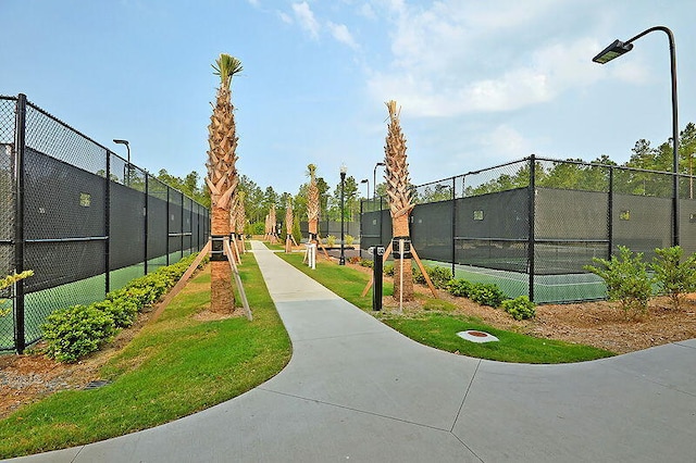 view of community featuring tennis court