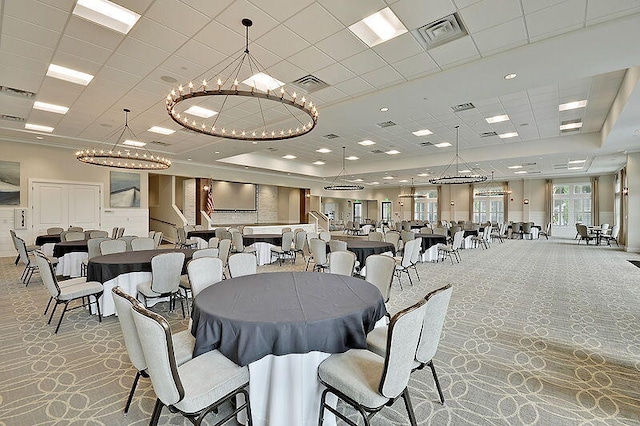 dining area featuring a paneled ceiling and an inviting chandelier