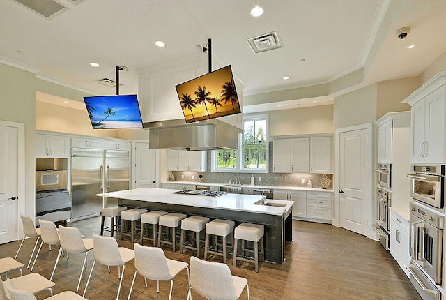 kitchen with a kitchen breakfast bar, a center island, white cabinets, and stainless steel appliances