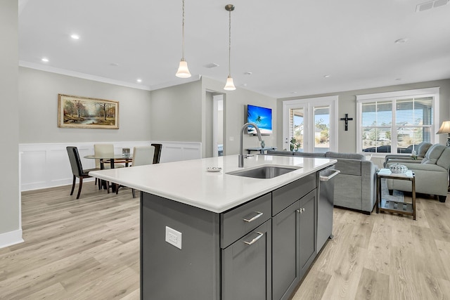 kitchen with sink, stainless steel dishwasher, a center island with sink, and light wood-type flooring