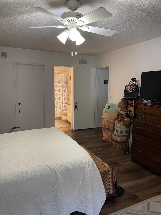 bedroom with dark hardwood / wood-style floors, a textured ceiling, connected bathroom, and ceiling fan